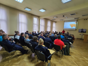 zdjęcie kolorowe, aula, policjanci od tyłu siedzą i słuchają wykładu