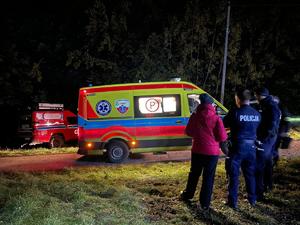zdjęcie kolorowe, policjanci stoją przy karetce