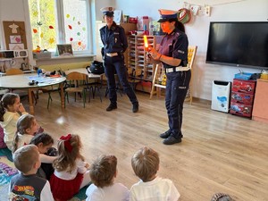 zdjęcie kolorowe w przedszkolu, policjantki stoją przed dziećmi