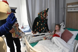 zdjęcie kolorowe w szpitalu, policjantka i sznupek rozdają prezenty