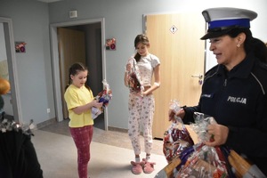 zdjęcie kolorowe w szpitalu, policjantka rozdaje dzieciom prezenty