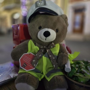 Pluszowa maskotka ubrana w odblaskową kamizelkę z czapką policyjna na głowie