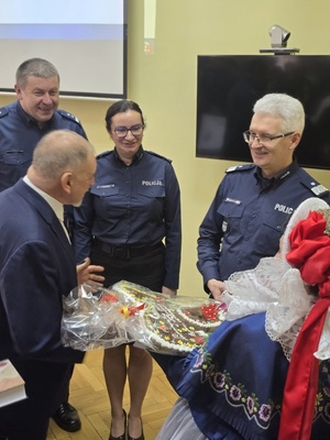 Komendant Wojewódzki Policji w Katowicach, Komendanci Komendy Powiatowej Policji w Żywcu, Burmistrz oraz asysta  w strojach regionalnych przekazująca Komendantowi Wojewódzkiemu pamiątkowy piernik, ciupagę oraz kapelusz góralski