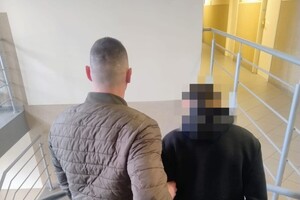 Zdjęcie przedstawia zatrzymanego nietrzeźwego kierującego, którego prowadzi policjant