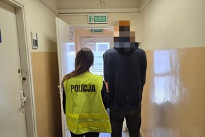 Zdjęcie przedstawia policjantkę prowadzącą zatrzymanego mężczyznę