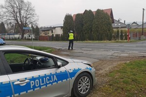 Zdjęcie przedstawia policjanta ruchu drogowego dokonującego pomiaru prędkości miernikiem